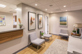 Dentist's office waiting room with wall art and comfortable seating 